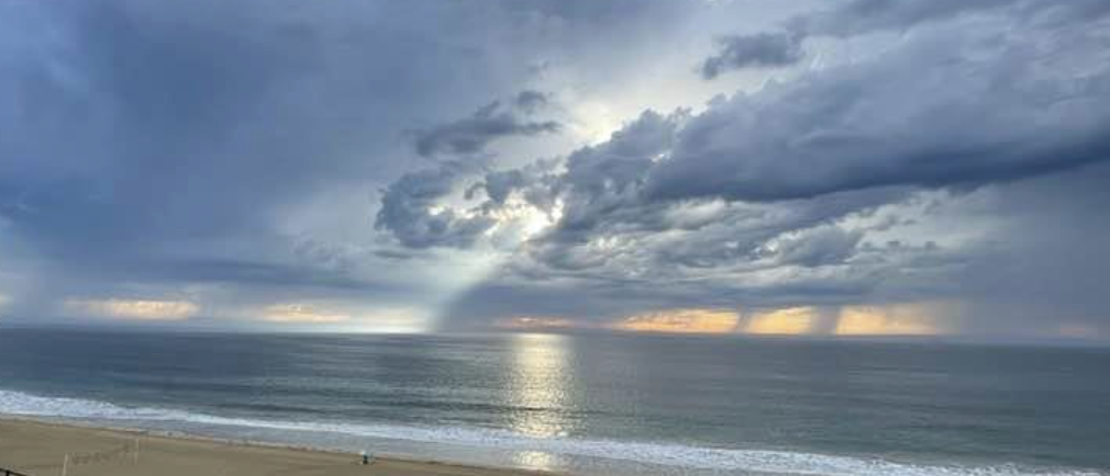 A beach with a body of water and clouds in the sky

Description automatically generated with low confidence